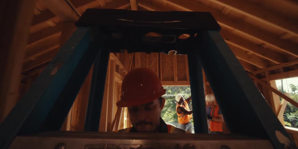 Man carrying a ladder inside a construction site