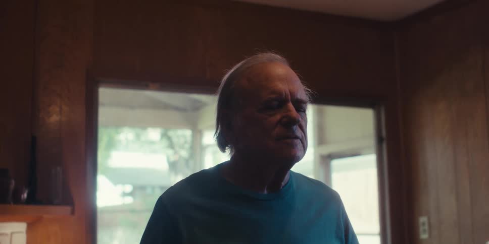 Elderly man performs a deep breathing exercise while standing at home
