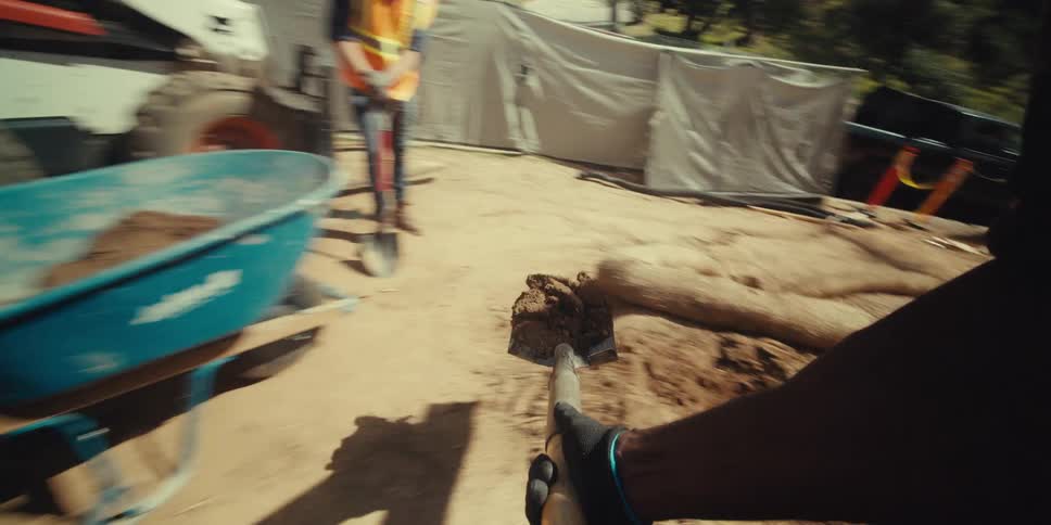 A construction worker is shoveling dirt