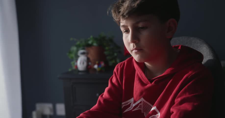 Focused boy typing on laptop