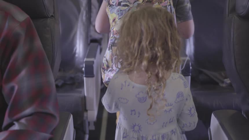 View of two children from behind walking down the aisle of a transport
