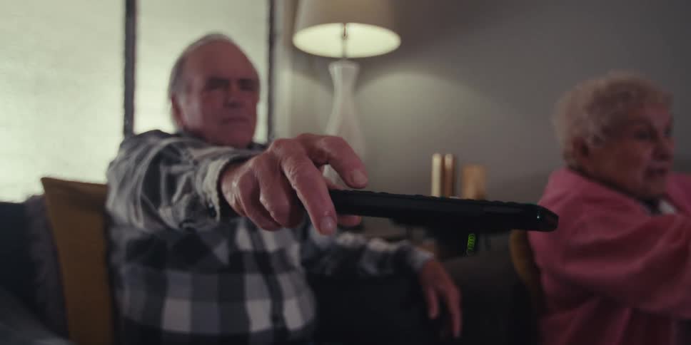 A man changes the channel with a remote