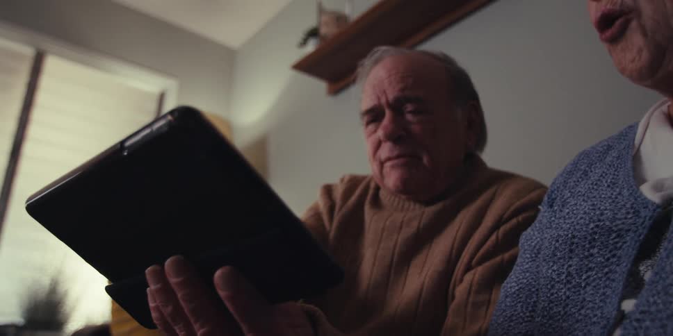 A woman taps the display on the tablet