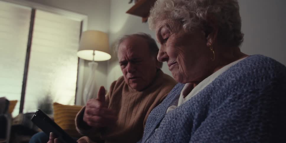 A man and woman talk and look at a tablet