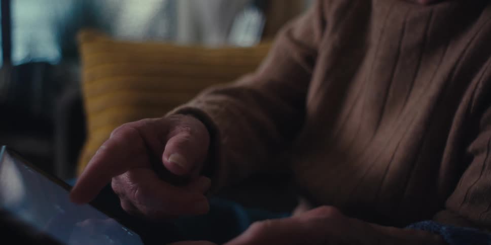 Two older people point at the monitor on the tablet
