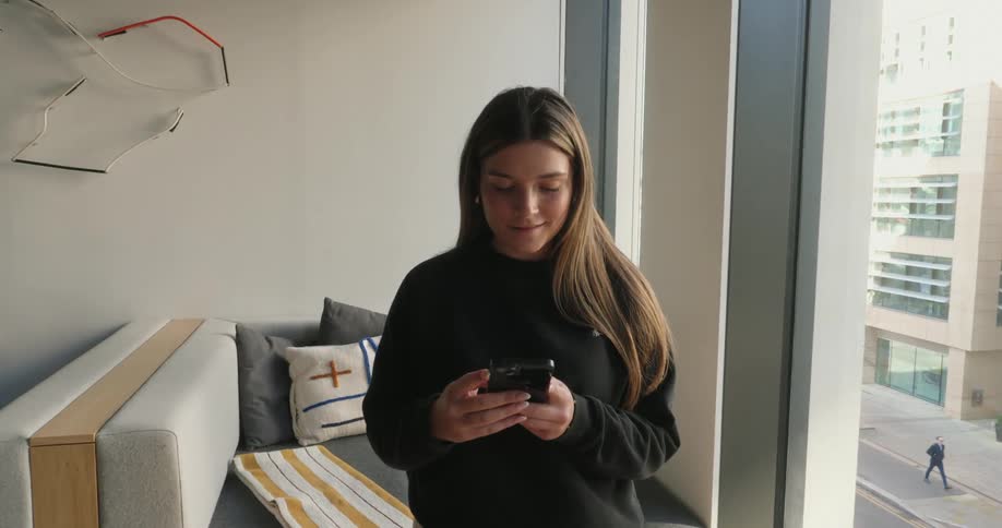 A girl is texting and smiling