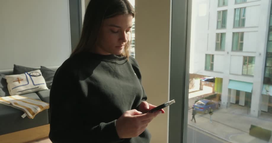 Concentrated woman typing on a smartphone