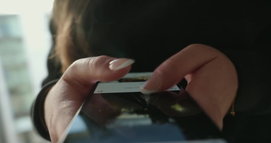 A girl is scrolling through a feed on her cell phone