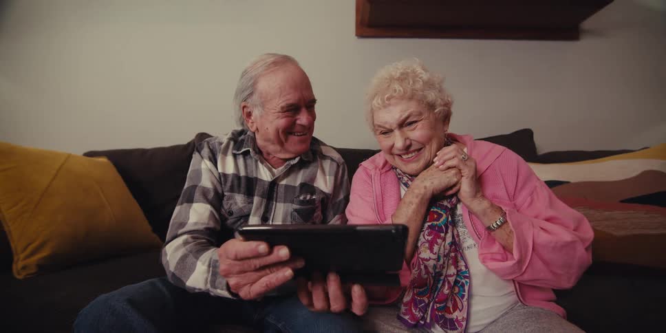 A footage of two elderly couples smiling and making a call