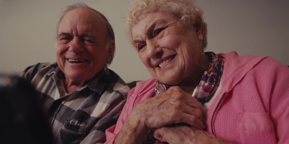 Senior couple reacting emotionally to tablet content