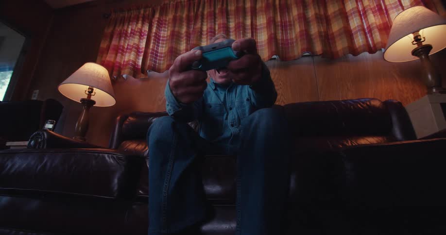 Elderly man having fun while playing video games