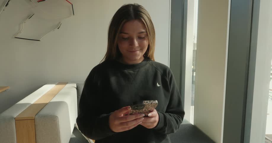 Young woman with happy facial expression holding a smartphone