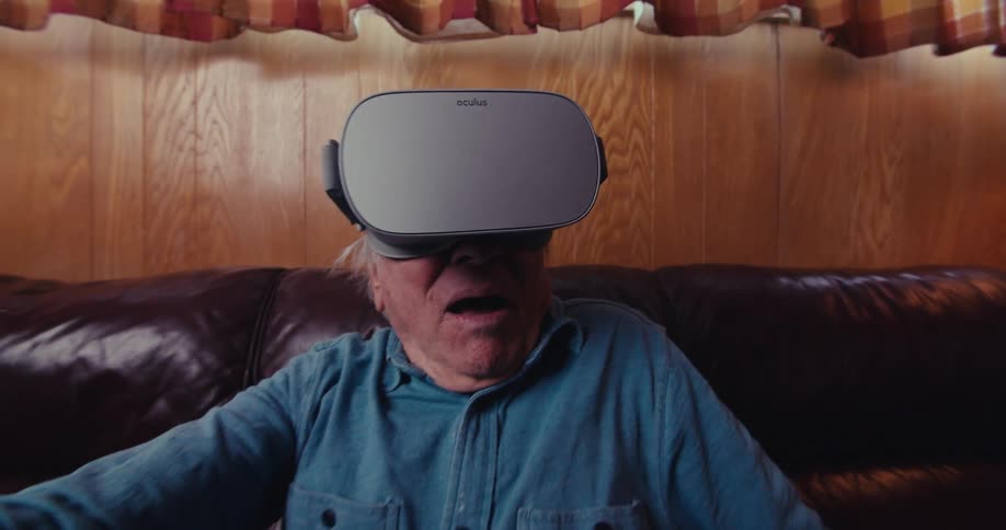 An elderly man is using a virtual reality headset
