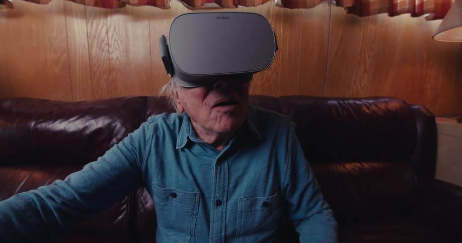 Elderly man sitting using virtual reality glasses