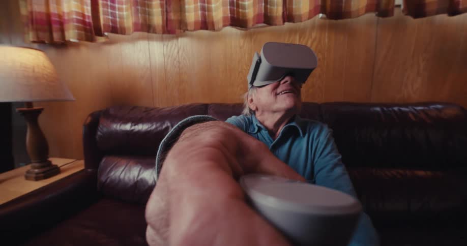A man smiles while waving a virtual reality controller