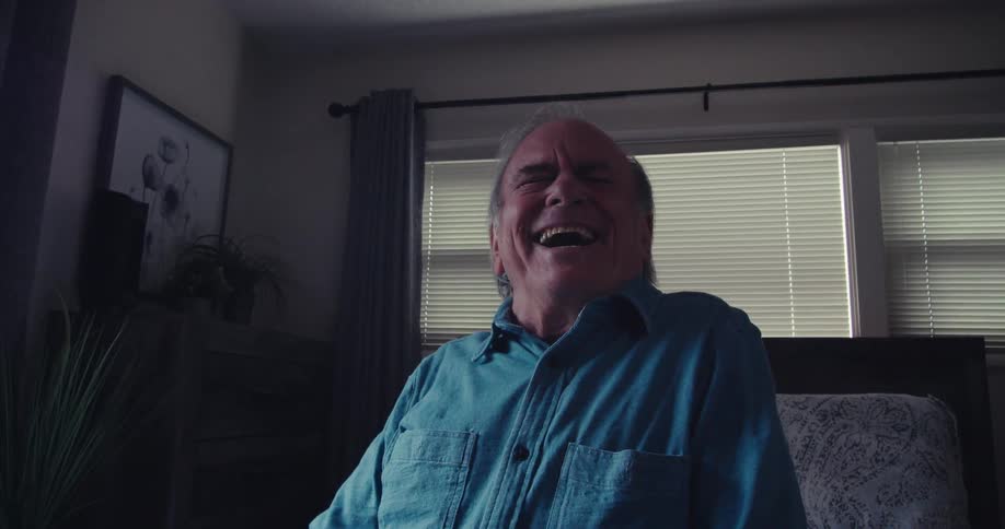 A man holding a remote is laughing