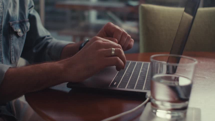 A man is typing on his laptop