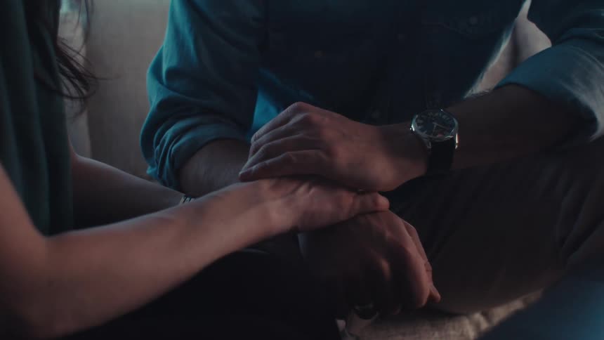 Close up of hands of two people holding hands