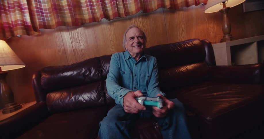 An elderly man playing an xbox game