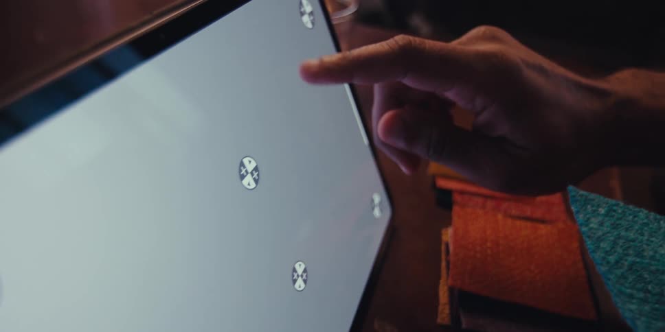 A man is touching the display on his tablet