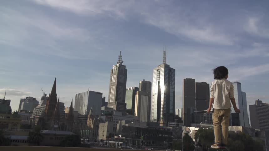 A child looks towards skyscrapers