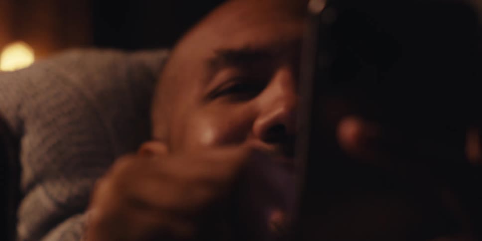Man smiling while swiping up on his phone