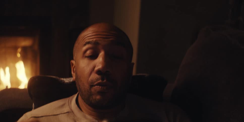 Man in a lowlight room interacting with smartphone