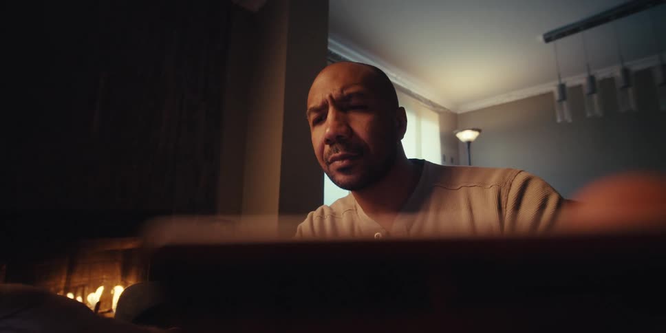 A man smiles and nods while looking at his tablet