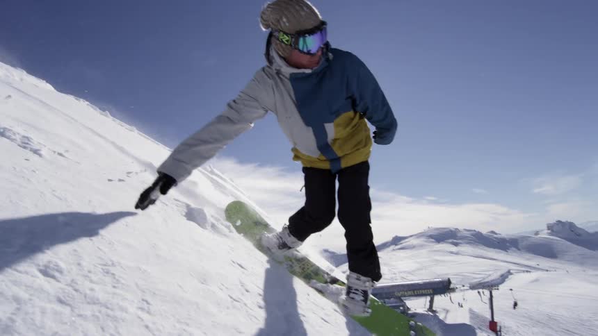 A snowboarder coming down a steep hill