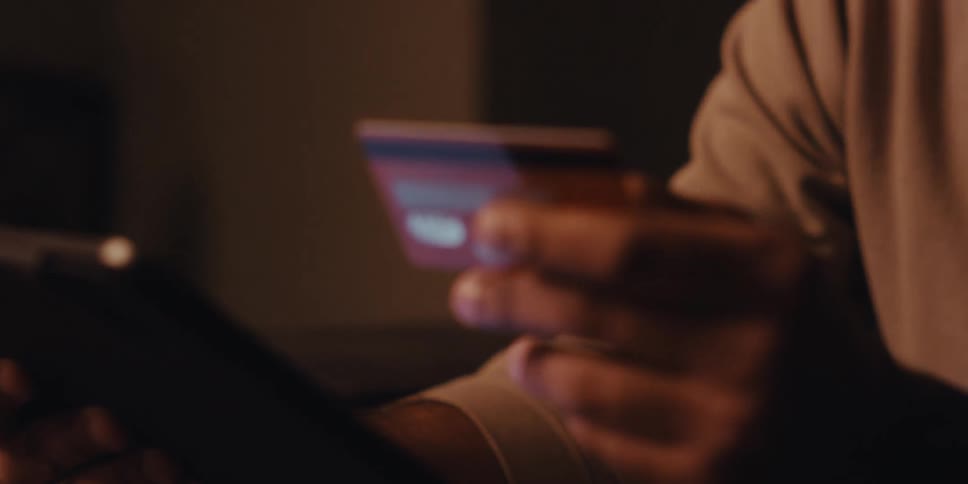 Hand holding a red credit card