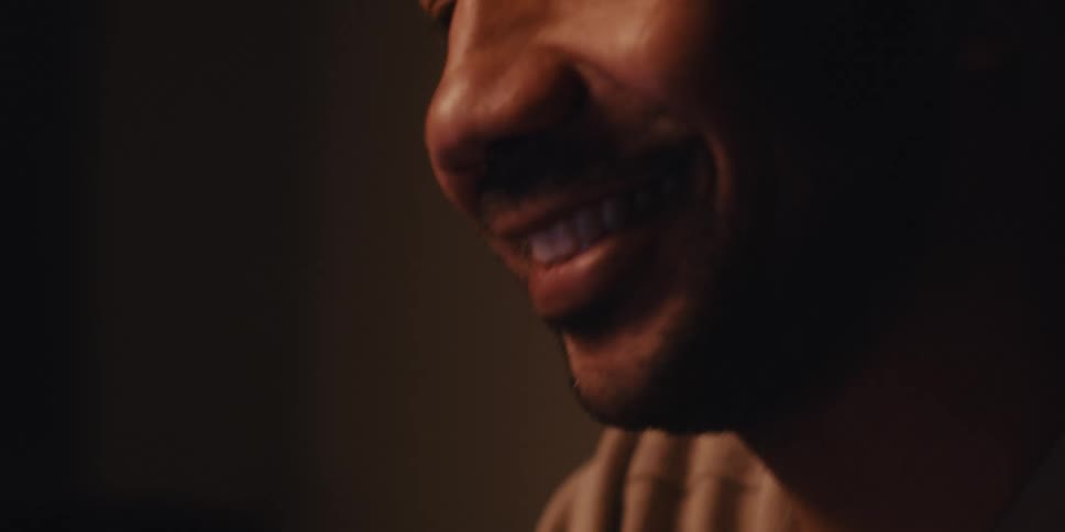 Man sitting in a room warmed by a fire smiles while entering his credit card information on his tablet