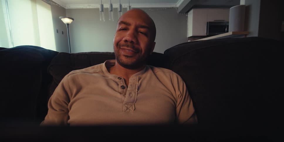 A footage of a person smiling while operating a device