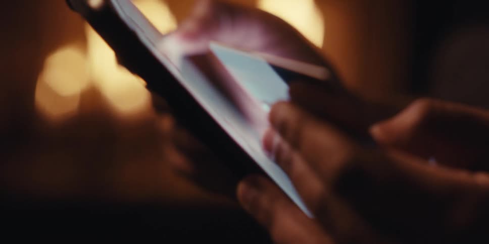 Man looking at tablet and scrolling a bit holding a credit card