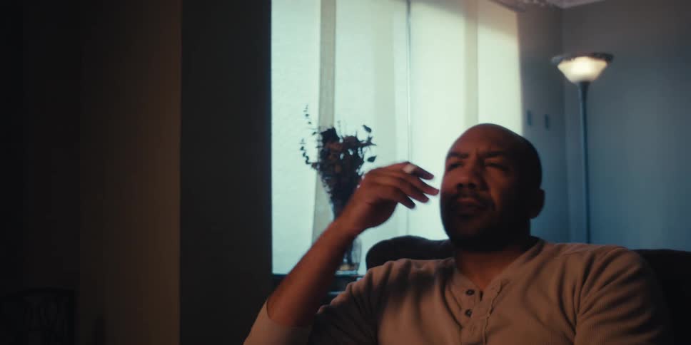 Man sitting in a sofa typing something on a tablet stops and thinks about it