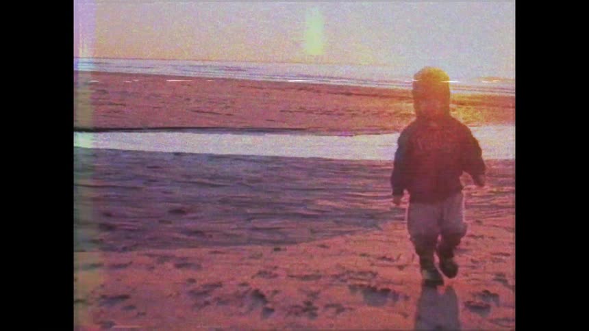 A footage of a toddler playing at the beach side