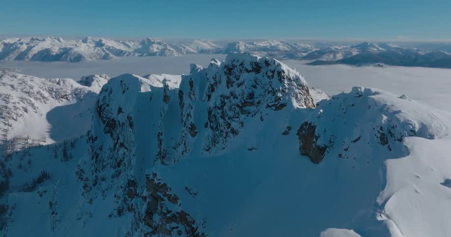An aerial view of a mountain peak with a snow covered surface