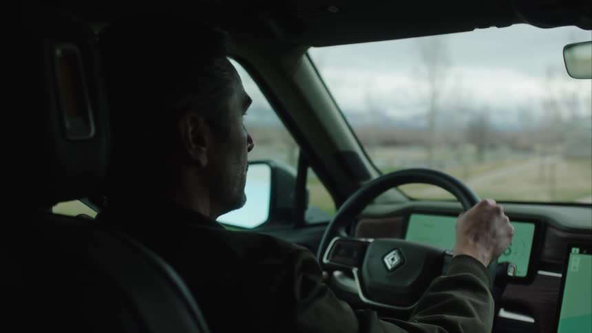 A man is driving past the trees