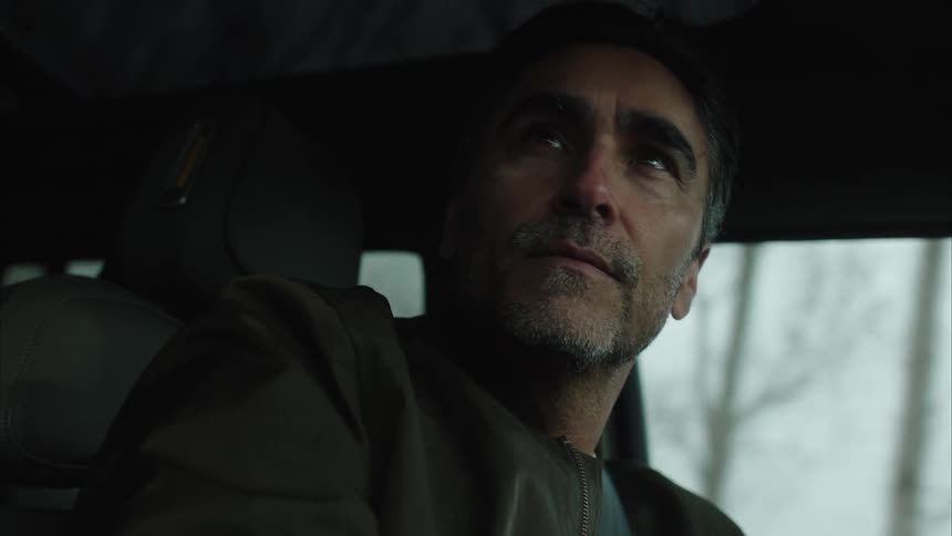 Man inside a moving vehicle showing a slight smile