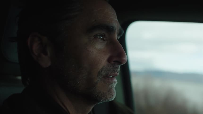 A man looks back and forth while driving