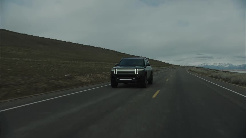 An suv driving down a road