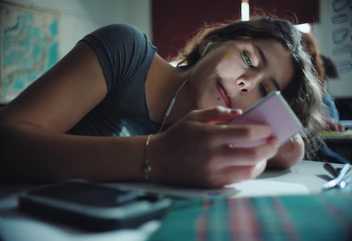 A student is using a mirror at her desk