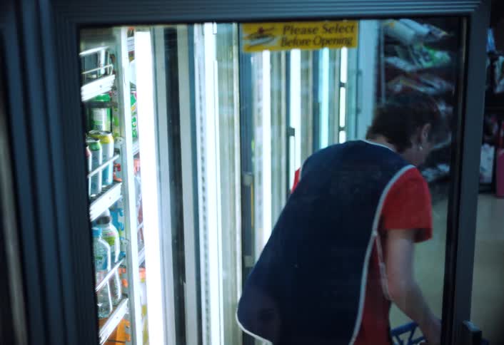 The worker is putting milk into the cooler