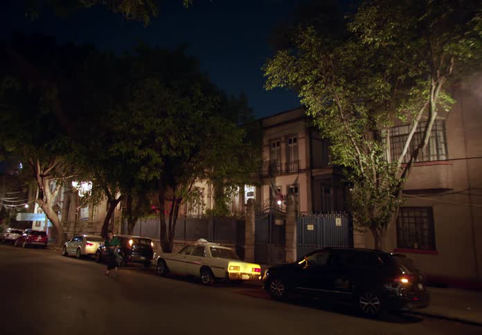 Car alarms flashing from cars parked on a street with apartment buildings