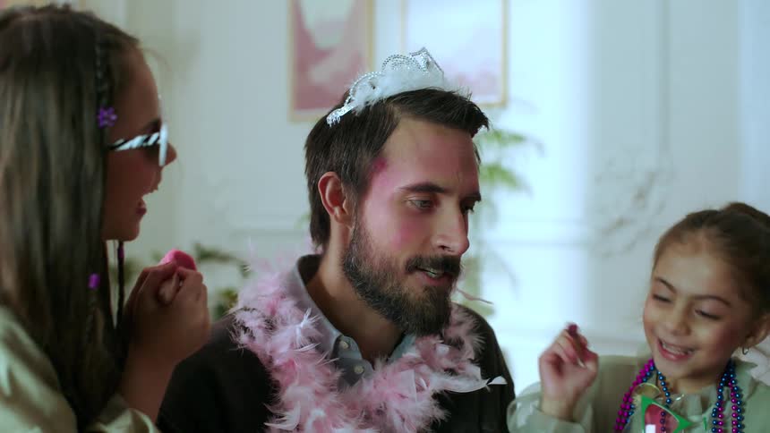 Father allowing his daughters to apply makeup to his face sighs when he spills his drink onto his laptop