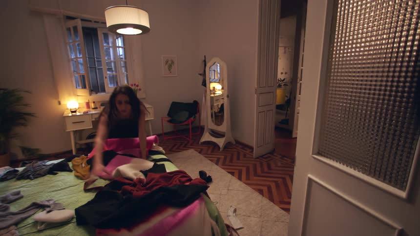 A girl is rushing around her bedroom searching for something