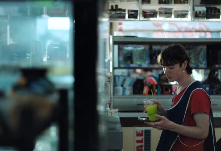 A bored store worker looks at their phone