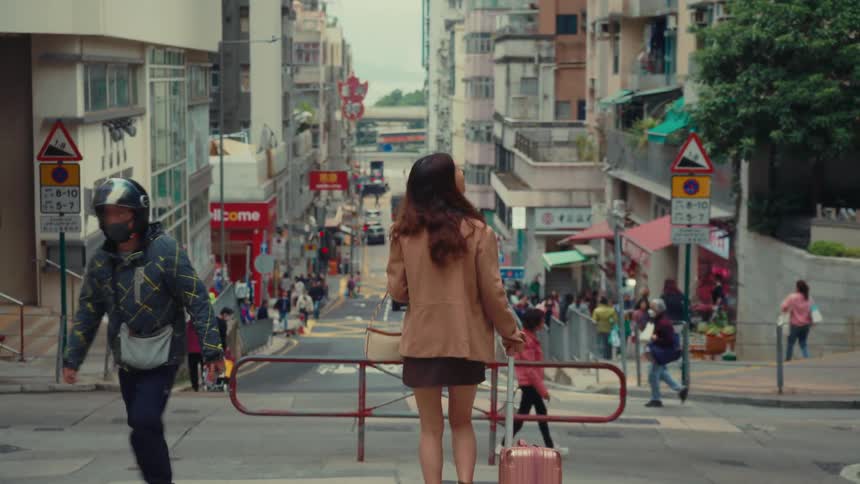 A woman drags her luggage in the city