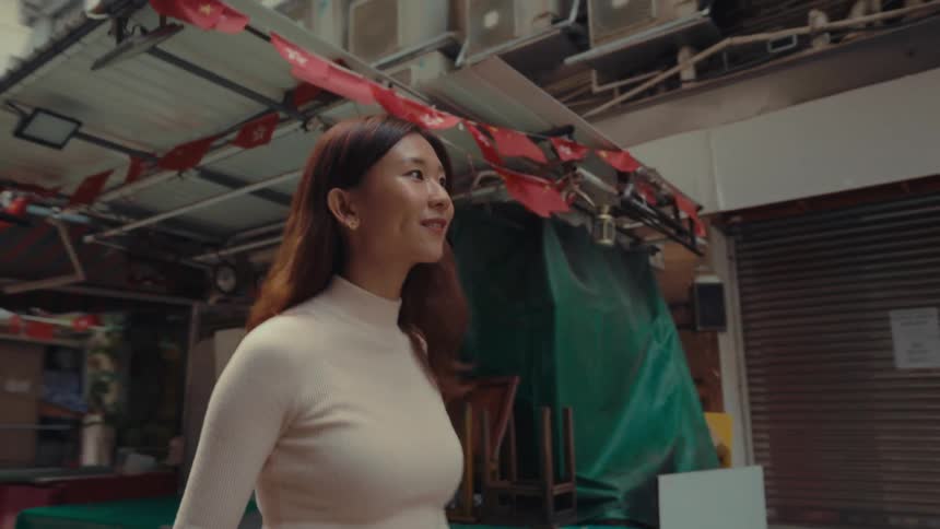 A woman is walking down the alley past the shops