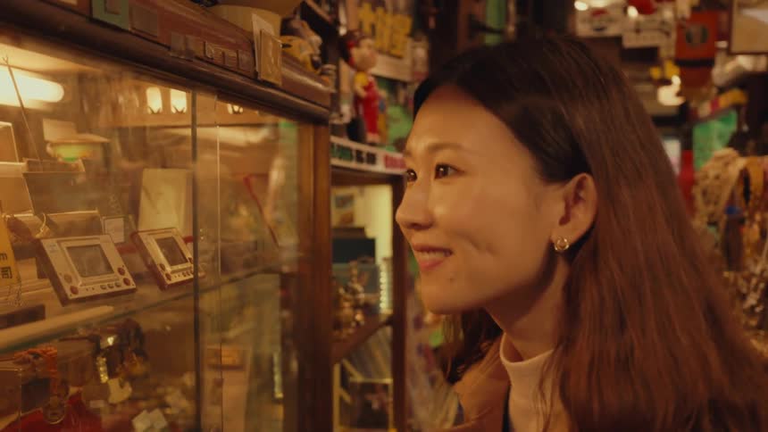 Asian girl inside a store looking happily and fascinated at old radios