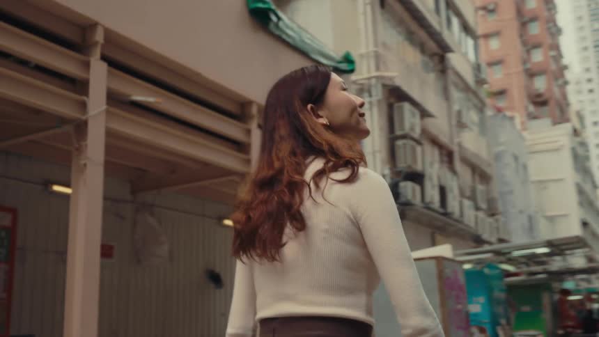 The woman stops in the alley to look at the shops